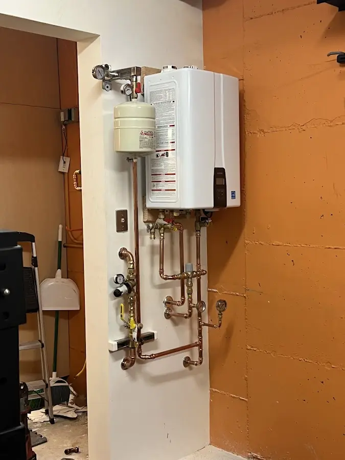 Plumbing technician inspecting water heater connections in North Yarmouth